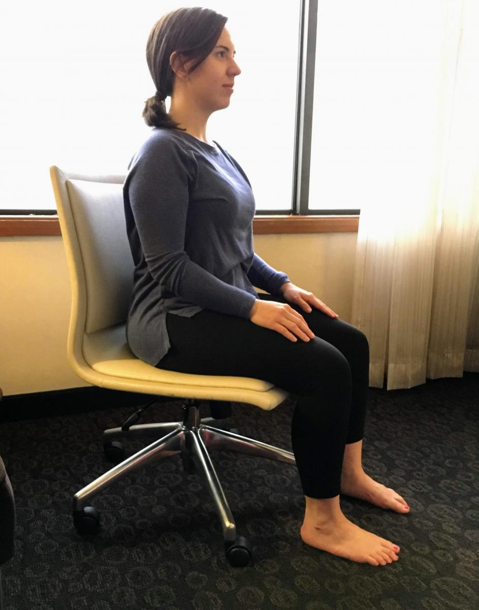 Woman sitting in chair with arms resting against her lap