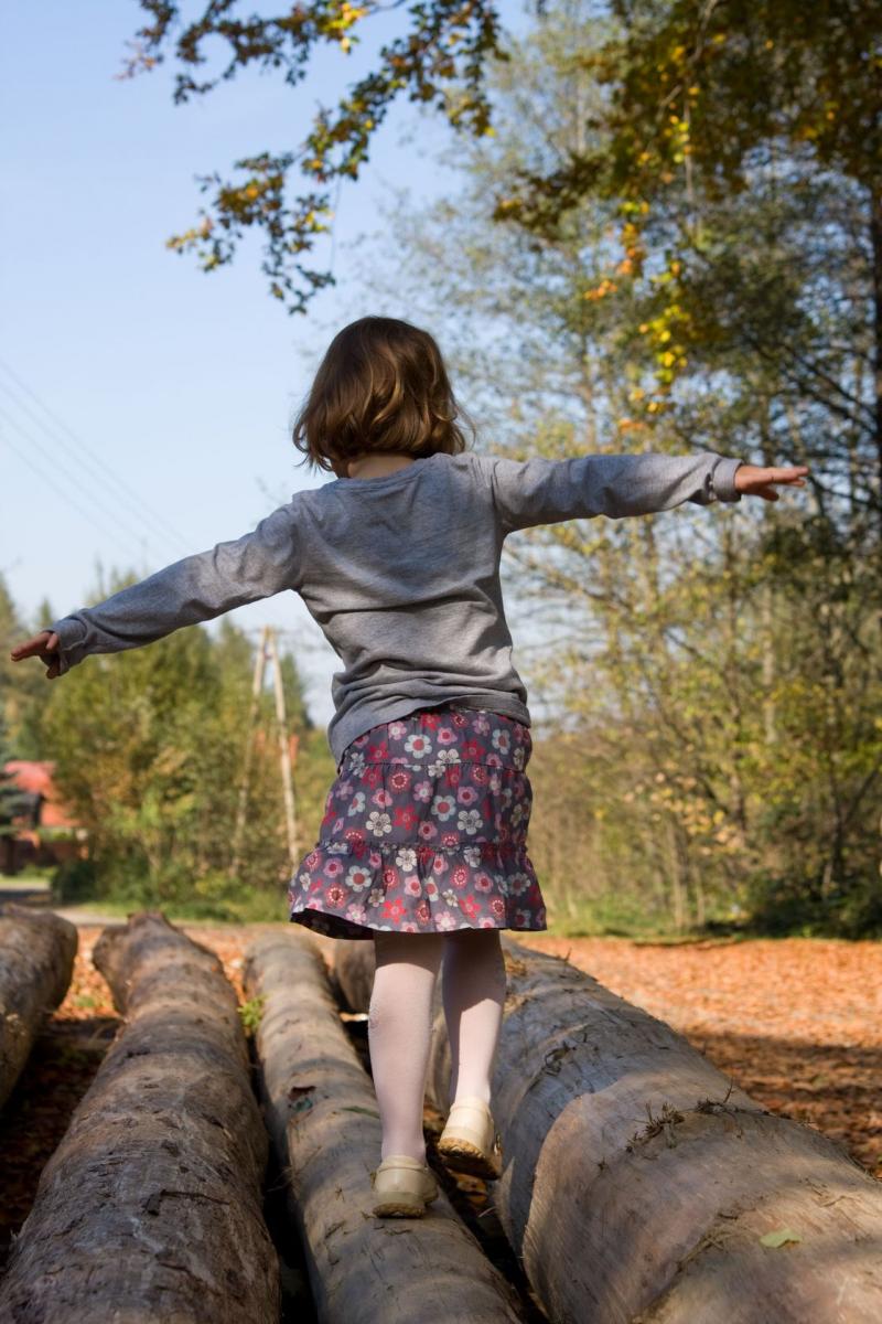 girl balancing on log