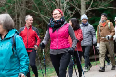 Woman walking with a group of people using Activator walking poles