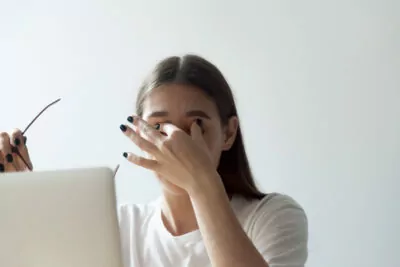 Tired female massaging eyes suffering from headache