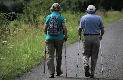 Older couple walking using poles