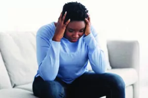 Tired black woman touching her head feeling stress