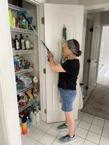 Karen using a grabber to get something from a high shelf.