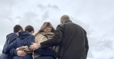 Family hugging (view from behind)