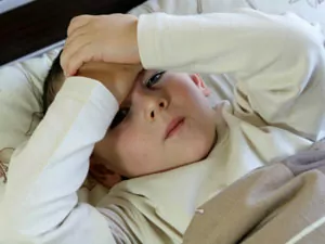 Young boy with his hands on his head.
