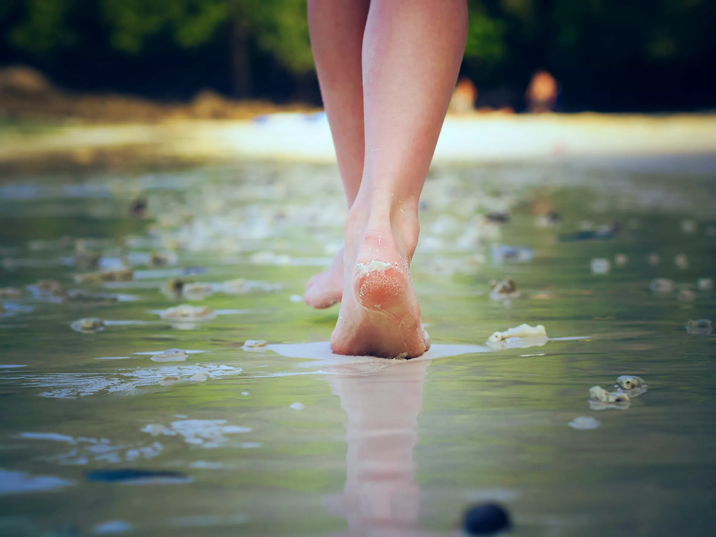 Girl walking on sand beach leaving footprints